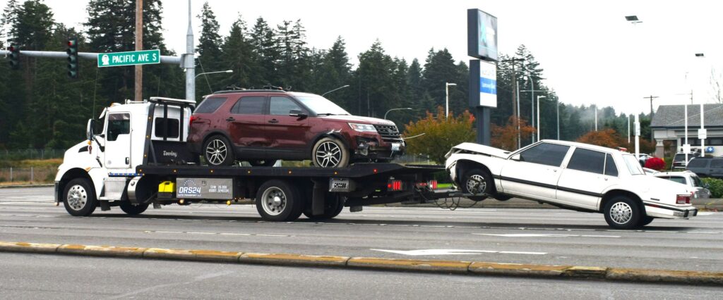 Flatbed recovery truck carrying a car